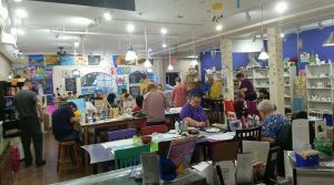 Group of people painting canvases together at a fundraising event inside Burst of Butterflies studio in Chandler, Arizona
